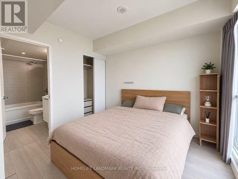 A bedroom with a large bed and a wooden bookshelf.