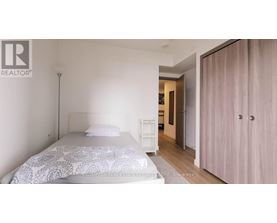 A bedroom with a bed, a nightstand, and a wardrobe.