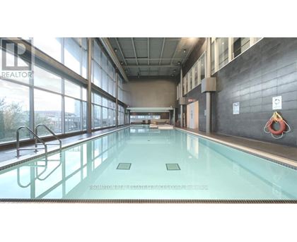 A large indoor swimming pool with a glass wall on one side.