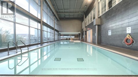 A large indoor swimming pool with a glass wall on one side.