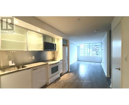 A kitchen with stainless steel appliances and wooden floors.