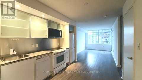 A kitchen with stainless steel appliances and wooden floors.