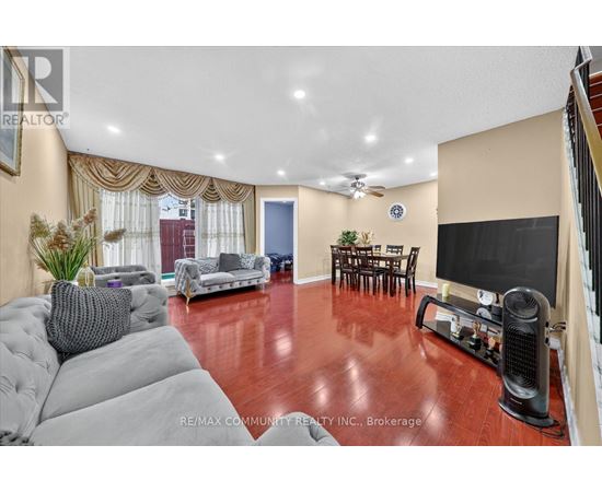 A living room with a grey sofa and a wooden floor.