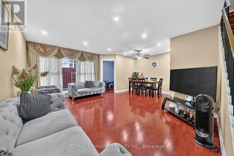 A living room with a grey sofa and a wooden floor.