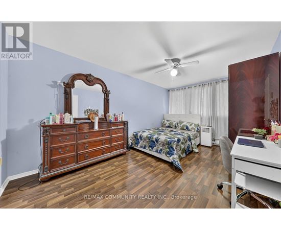 A bedroom with a large dresser and a bed with a blue and white comforter.