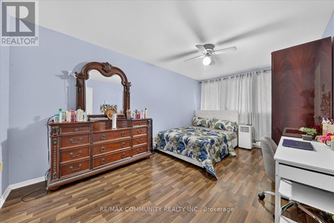 A bedroom with a large dresser and a bed with a blue and white comforter.
