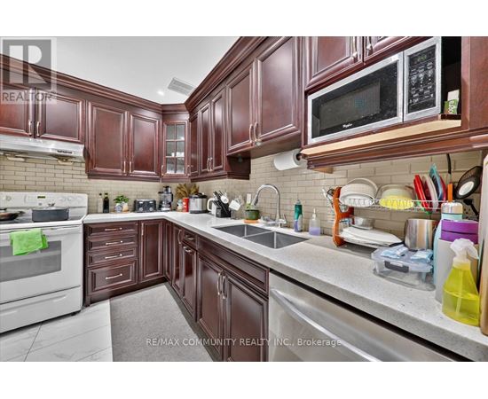 A kitchen with brown cabinets and a white stove top oven.
