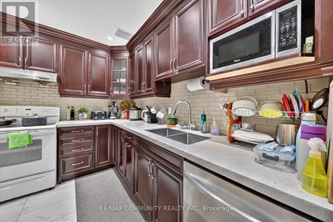 A kitchen with brown cabinets and a white stove top oven.