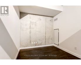 A room with a white wall and a concrete block wall.