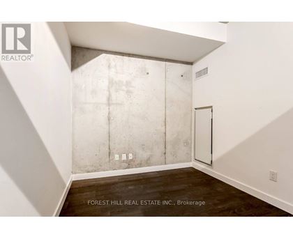 A room with a white wall and a concrete block wall.