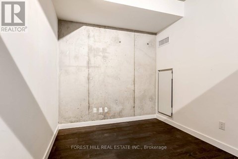 A room with a white wall and a concrete block wall.