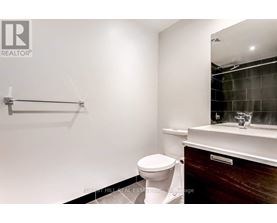 A bathroom with a toilet, sink, and mirror.