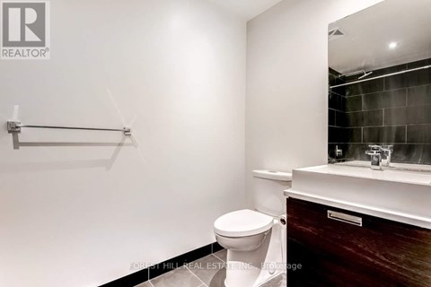 A bathroom with a toilet, sink, and mirror.