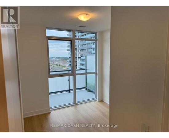 A room with a sliding glass door leading to a balcony.