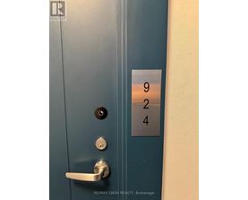A blue door with a silver handle and a sign with the numbers 924 on it.