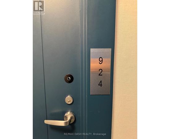 A blue door with a silver handle and a sign with the numbers 924 on it.