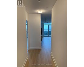 A hallway with a door leading to a balcony.