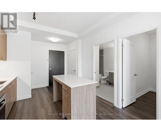 A kitchen with a white counter top and wooden cabinets.