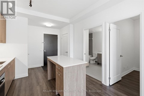A kitchen with a white counter top and wooden cabinets.