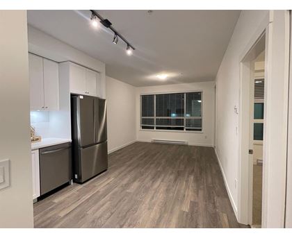 A kitchen with a refrigerator and cabinets.