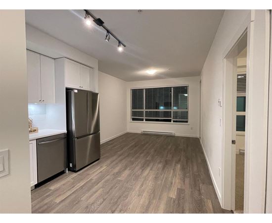 A kitchen with a refrigerator and cabinets.