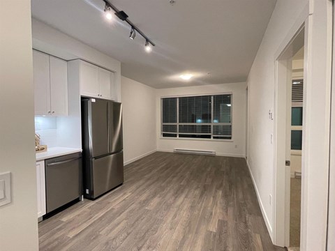 A kitchen with a refrigerator and cabinets.