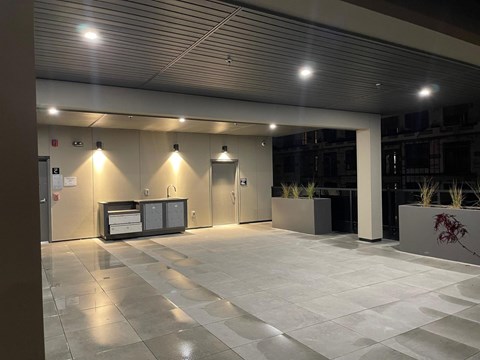 A modern building lobby with a reception desk and potted plants.