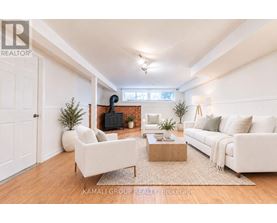 A living room with a white couch, a coffee table, and a fireplace.