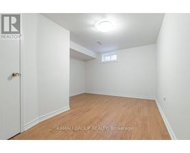 A room with wooden flooring and a window in the corner.
