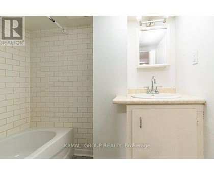 A white bathroom with a tub, sink and medicine cabinet.