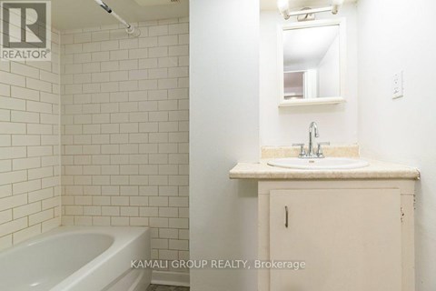 A white bathroom with a tub, sink and medicine cabinet.