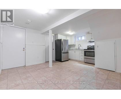 A kitchen with a refrigerator, sink, and oven.