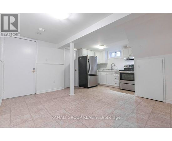 A kitchen with a refrigerator, sink, and oven.