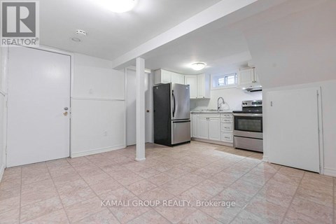 A kitchen with a refrigerator, sink, and oven.
