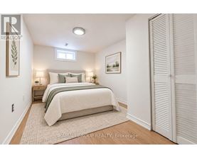 A bedroom with a bed, nightstands, and a painting on the wall.
