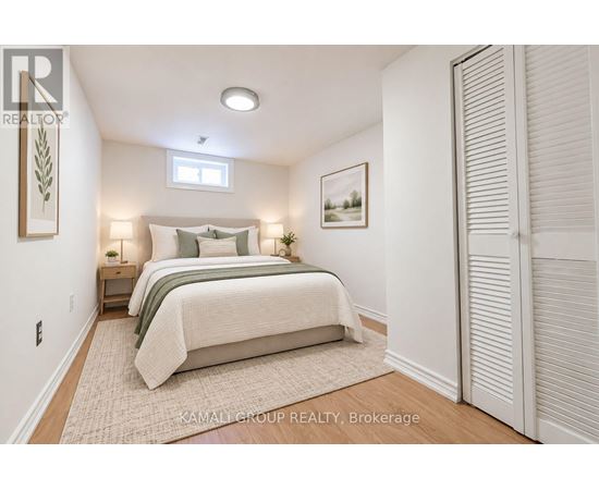 A bedroom with a bed, nightstands, and a painting on the wall.