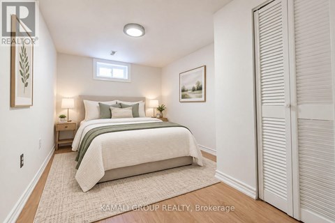 A bedroom with a bed, nightstands, and a painting on the wall.