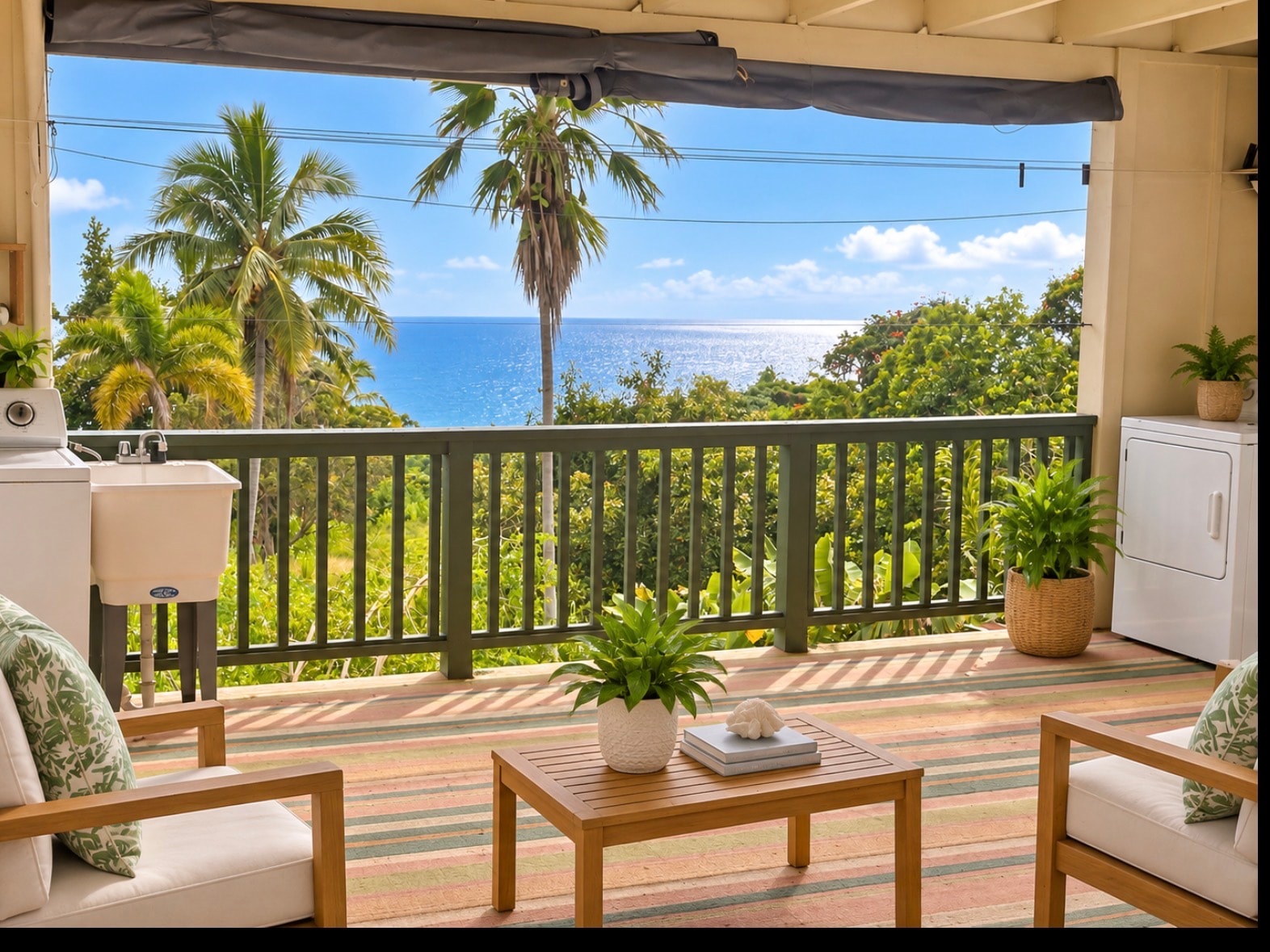 A balcony with a table and chairs overlooking the ocean.