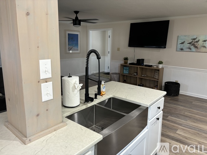 A kitchen with a sink and a wooden column.