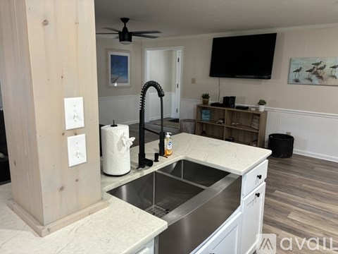 A kitchen with a sink and a wooden column.