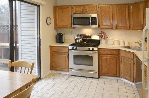 A kitchen with wooden cabinets and white appliances.