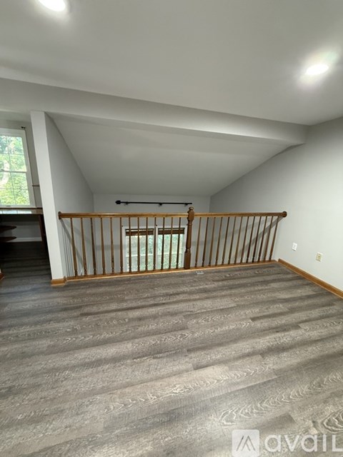 A room with a wooden railing and a window.