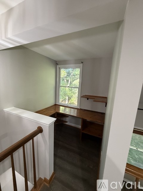 A room with a window and a wooden bench.
