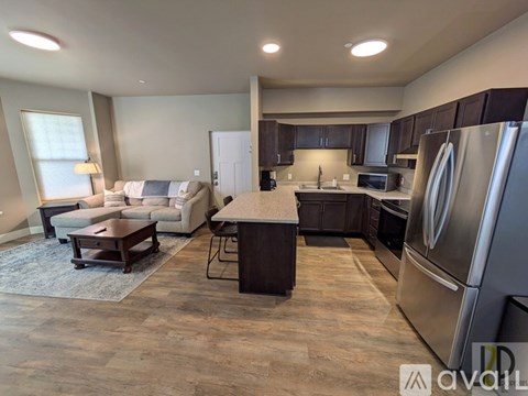 A modern kitchen with dark wood cabinets and stainless steel appliances.