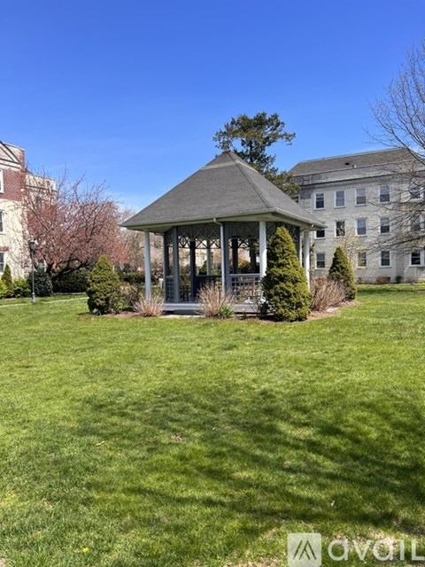 A gazebo sits in the middle of a grassy field.