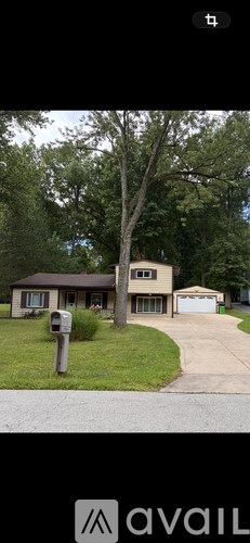 A house with a brown roof and a grey garage door.