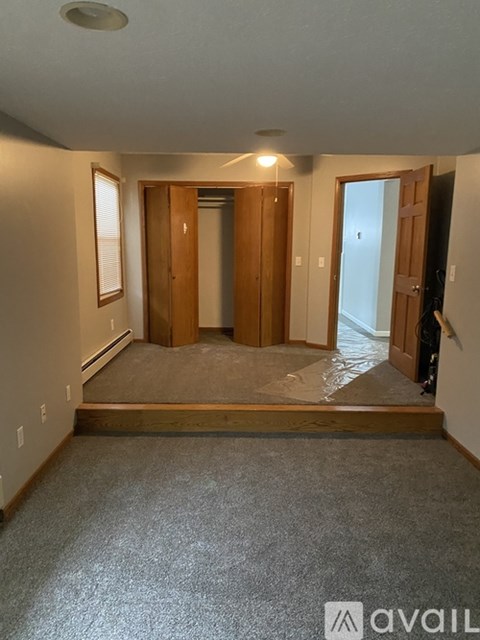 A room with a carpeted floor and a doorway leading to another room.