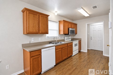 A kitchen with wooden cabinets and white appliances.