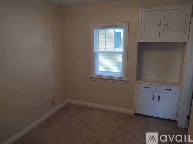 A room with a window and a cabinet.