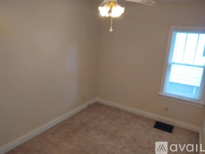 A room with a ceiling fan and a window.